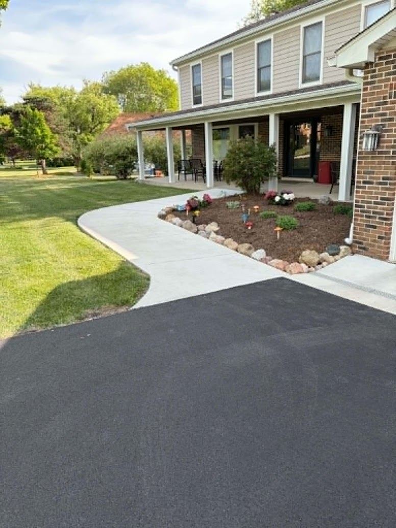 New asphalt driveway with redone concrete walkway to the front porch