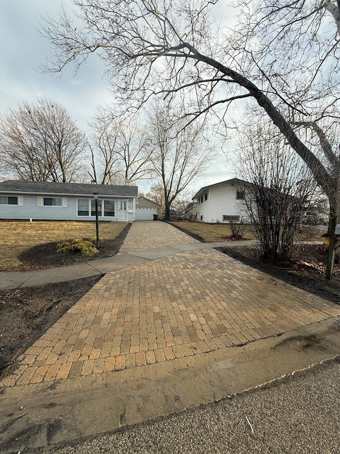 Completed brick paver driveway with two-tone Belgian-style pattern